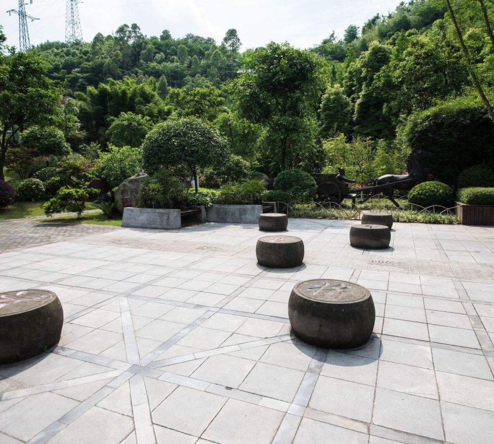 Stone courtyard with benches and trees in background